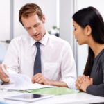 An image of a professional and client sitting together, looking over documents. Learn more about due diligence here!